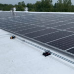 Commercial roof restoration in Detroit featuring reflective white metal roofing with proper ventilation systems
