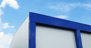 Modern industrial warehouse with blue metal roofing and white walls - durable industrial roofing solutions for large facilities