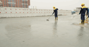 Professional technicians applying protective coating during flat roof puncture repair on a commercial building.
