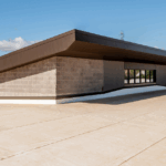 Flat commercial roof under clear skies, ideal for assessing roof replacement vs repair needs.