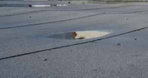 Ponding water on flat roof causing drainage problems in Detroit.
