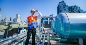 Inspector reviewing rooftop mechanical systems to support an accurate commercial roof cost estimate for an urban building.