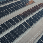 Roof coating for solar panels protecting a commercial flat roof under a solar array