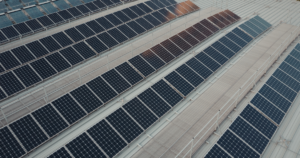 Roof coating for solar panels protecting a commercial flat roof under a solar array