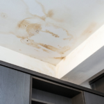 Commercial building interior showing active water intrusion during a roof leak insurance claim assessment after storm damage