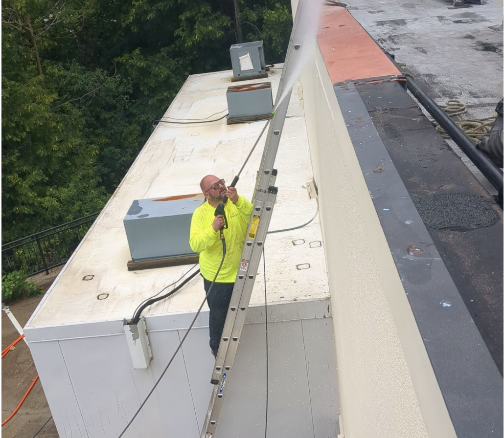 Technician inspecting HVAC roof penetrations during a commercial roof inspection