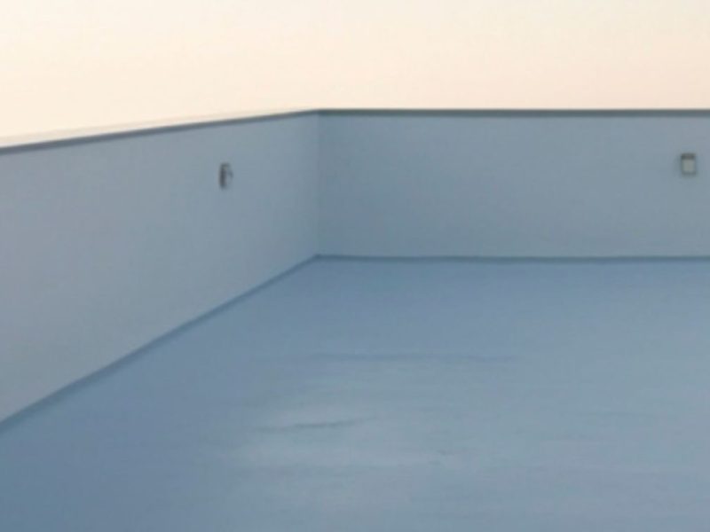 completed commercial roof coating - white reflective silicone coating on flat commercial roof